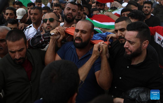 Para pelayat membawa jenazah Osama Adawi, selama pemakamannya di Hebron, Tepi Barat