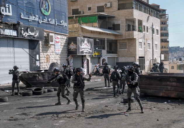 Pasukan Israel mengambil posisi selama bentrokan dengan demonstran Palestina setelah tentara memasuki kamp pengungsi Shuafat