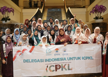 A group of people holding a banner Description automatically generated