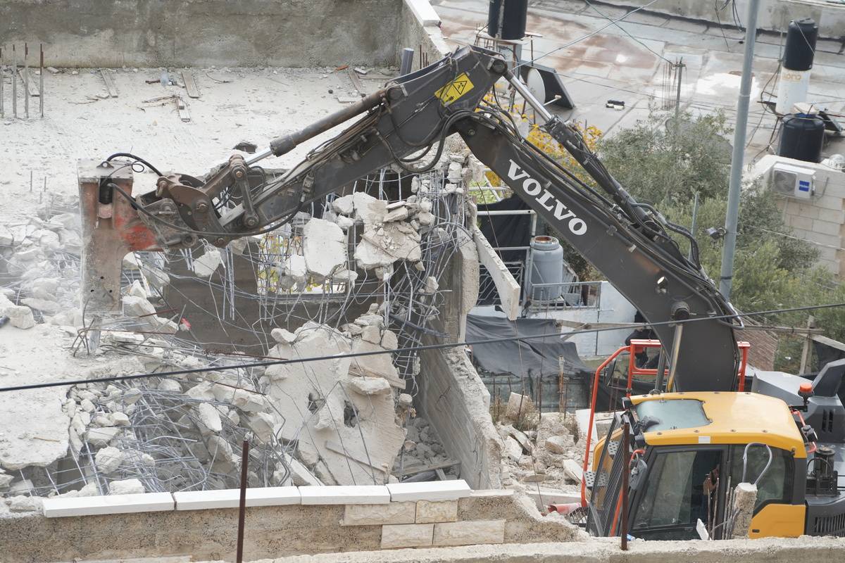 A heavy duty machine of Israeli forces demolishes Palestinian house in East Jerusalem, on January 4, 2023 [Saeed Qaq/Anadolu Agency]