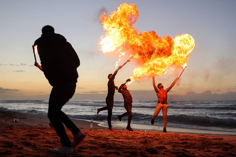 Palestinians demonstrate their fire breathing in Gaza city. Often their performances include shows of gymnastic prowess such as turning somersaults. 