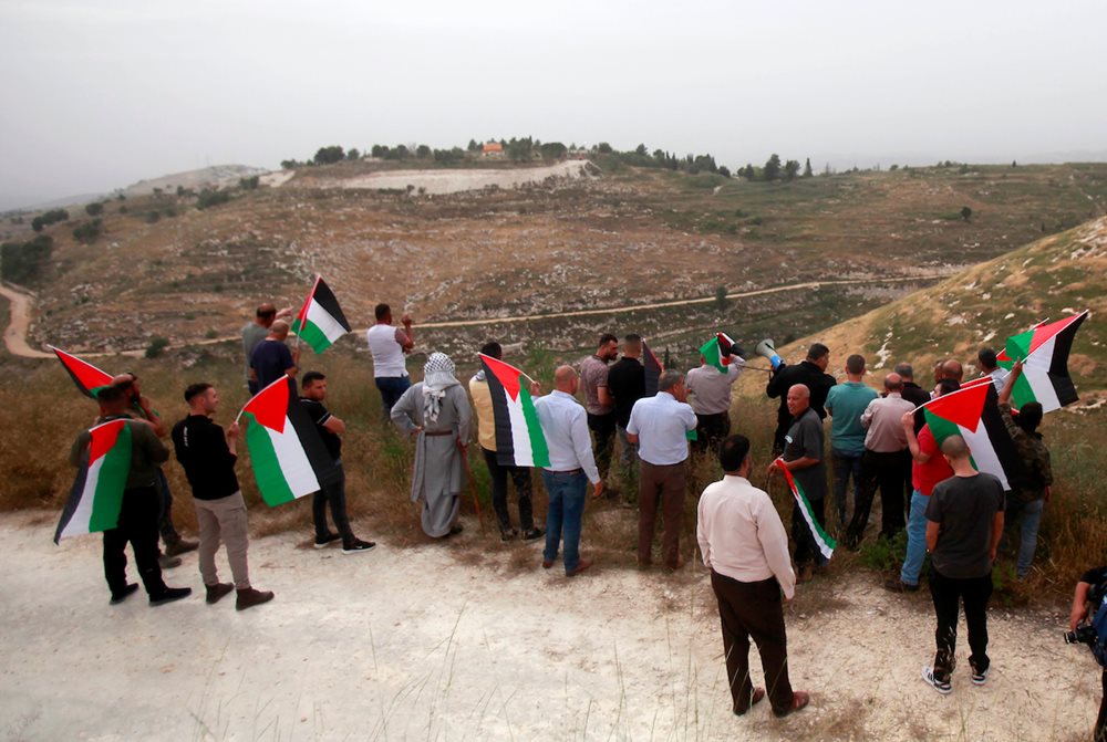 Protesters raise the Palestinian flags during a protest against the expansion of settlements in Burqa town, northwest of the West Bank city of Nablus on May 27, 2023. Israeli settlers escalate violence against Palestinian families and lands in Burqa, occupied Nablus, burned the farmers’ fields, and attacked properties.
