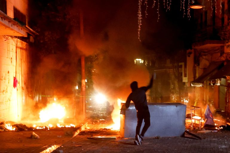 A Palestinian throws stones as the Israeli army raids Ramallah, in the Israeli-occupied West Bank, June 8, 2023. REUTERS/Mohammed Torokman