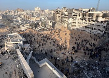 Palestinians gather around the burned and destroyed Al-Shifa Hospital