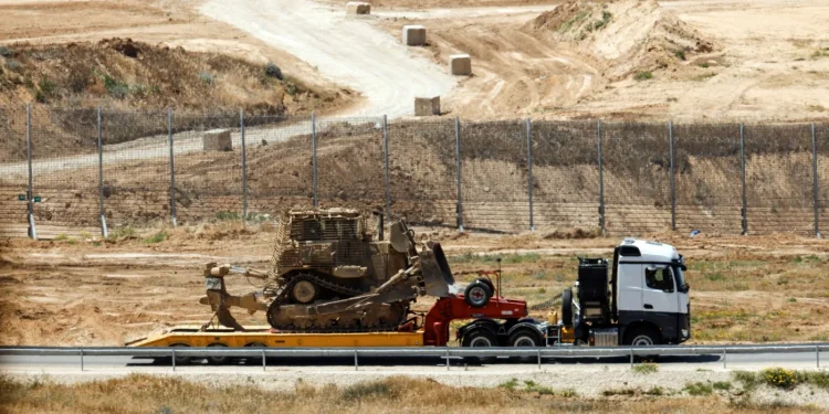 Pemandangan truk pengangkut buldozer militer Israel di dekat pagar perbatasan Israel-Gaza, terlihat dari Israel, 20 April 2025 (Amir Cohen/ Reuters)