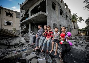 Anak-anak Palestina duduk di atas puing-puing rumah mereka di Deir al-Balah, Jalur Gaza tengah (APA Images)