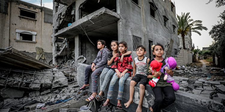 Anak-anak Palestina duduk di atas puing-puing rumah mereka di Deir al-Balah, Jalur Gaza tengah (APA Images)