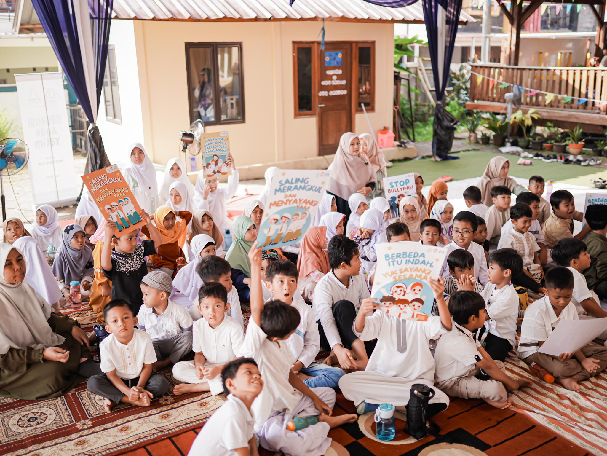 Anak-anak menyerukan yel-yel dalam rangka Hari Anak Nasional sambil mengangkat poster anti kekerasan.