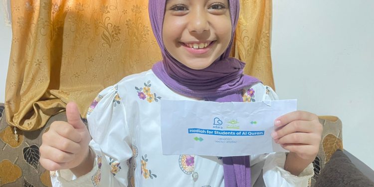 Ragad Nadim Aga menerima hadiah dari program HAQ karena telah memeroleh juara pertama di sekolahnya [Dok. Penyaluran Adara 2025]