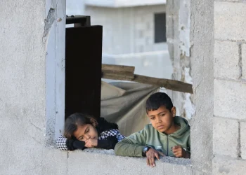 Anak-anak Palestina melihat lokasi serangan Israel di sebuah bangunan tempat tinggal di Kota Gaza (Reuters/Dawoud Abu Alkas/MEE)