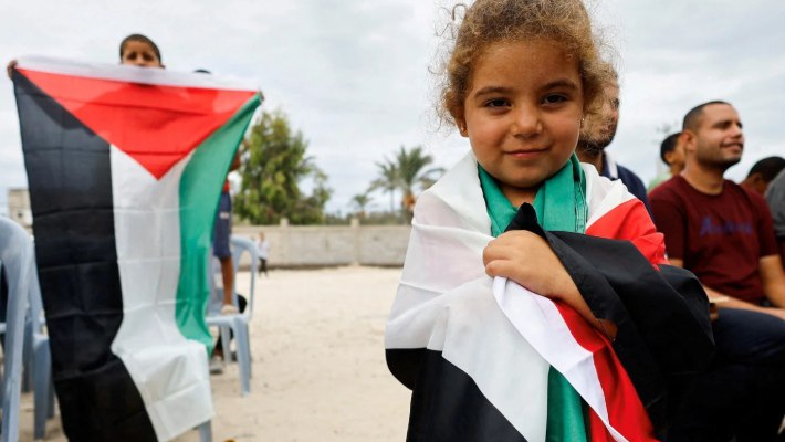 Gadis kecil Gaza memeluk bendera Palestina setelah pengumuman gencatan senjata (MEE)