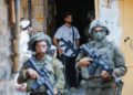 Tentara Israel melindungi pemukim ilegal yang membawa senjata di Hebron, Tepi Barat (Al Jazeera)