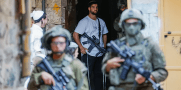 Tentara Israel melindungi pemukim ilegal yang membawa senjata di Hebron, Tepi Barat (Al Jazeera)