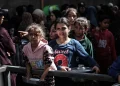 Warga Palestina, termasuk anak-anak, menunggu dengan panci untuk menerima makanan hangat yang didistribusikan oleh lembaga amal, sementara mereka berjuang melawan kelaparan akibat blokade makanan Israel di kamp pengungsi Nuseirat di Kota Gaza, Gaza pada 21 Oktober 2025. [Moiz Salhi – Anadolu Agency]