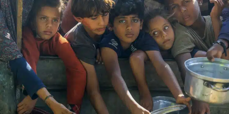 Warga Palestina, termasuk anak-anak, mengantre panjang untuk menerima makanan hangat yang didistribusikan oleh berbagai lembaga amal di wilayah al-Mawasi, Khan Yunis, Gaza, pada 5 November 2025. [Abed Rahim Khatib – Anadolu Agency]