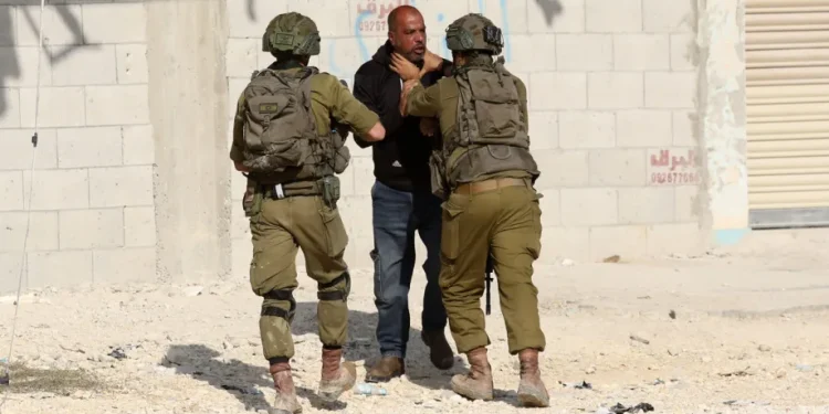 Tentara Israel mengintervensi warga Palestina sementara tim Bulan Sabit Merah memindahkan korban luka ke rumah sakit setelah tentara Israel melukai dua warga Palestina, seorang anak dan seorang jurnalis, di Kamp Nur Shams di kota Tulkarem, Tepi Barat pada 18 November 2025. [Nedal Eshtayah – Anadolu Agency]