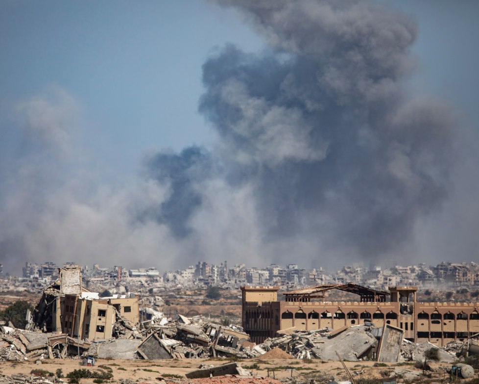 Asap mengepul dari Kota Gaza setelah serangan udara pada Kamis (2/10). Israel menggencarkan serangan di seluruh Gaza, termasuk di “zona aman” Al-Mawasi dan menyebabkan 53 orang Palestina terbunuh. (Haitham Imad/EPA/Al Jazeera/The Guardian)