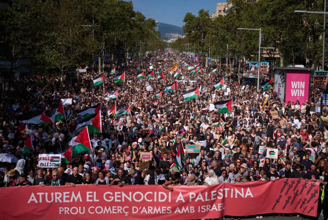 Para demonstran membentangkan spanduk bertuliskan "Mari kita hentikan genosida di Palestina, hentikan perdagangan senjata dengan Israel" dalam unjuk rasa pro-Palestina di Barcelona (4/10). Unjuk rasa ini dilakukan sebagai bentuk solidaritas dengan Armada Sumud Global setelah kapal-kapal mereka dicegat oleh angkatan laut Israel. (Emilio Morenatti/AP Photo) 