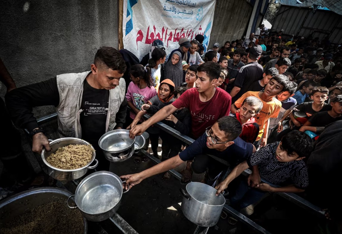 Warga Palestina memadati titik distribusi makanan di Nuseirat, Gaza, pada Rabu (8/10). Penduduk Gaza terus berjuang menghadapi rekayasa kelaparan dan serangan Israel, sementara pembicaraan tentang kesepakatan yang akan mengakhiri pertempuran di wilayah tersebut masih terus berlangsung dan mulai mencapai titik terang. (Khames Alrefi/Anadolu/CNN) 