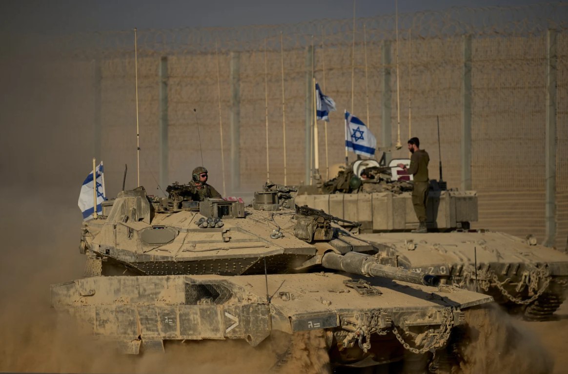 Tank-tank Israel bergerak di sepanjang perbatasan Israel-Gaza pada Senin (20/10). Sehari sebelumnya, Israel mengancam akan menghentikan izin pengiriman bantuan kemanusiaan, sementara pasukannya melancarkan serangan yang membunuh puluhan warga Palestina. Israel kemudian mengatakan telah melanjutkan penegakan gencatan senjata. (Ohad Zwigenberg/AP Photo)