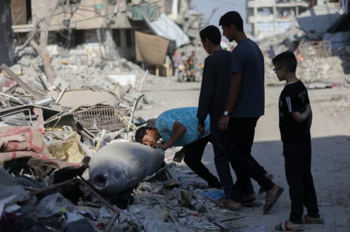 Seorang anak laki-laki memeriksa persenjataan Israel yang belum meledak di Yarmouk, Kota Gaza (30/10). Meski dalam situasi gencatan senjata, Gaza terus menghadapi “agresi senyap” akibat ribuan persenjataan yang belum meledak tersebar di lingkungannya. Tanpa tim yang membersihkan senjata-senjata yang belum meledak ini, warga sipil Palestina menghadapi bahaya serius setiap hari. (Yousef Zaanoun/ActiveStill)