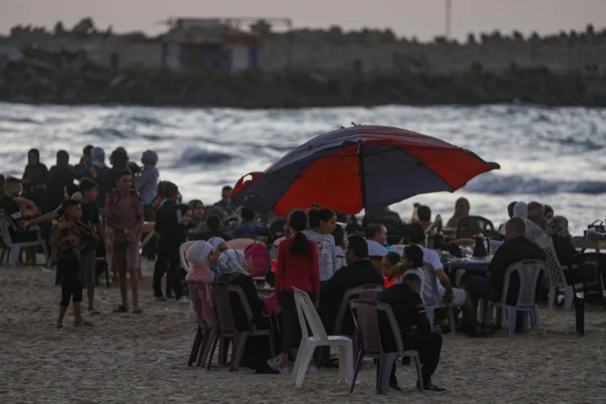 Warga Palestina menghabiskan waktu mereka di pantai saat matahari terbenam di tengah gencatan senjata antara Israel dan Hamas di sebelah barat Kota Gaza (31/10). Di antara hal yang mengobati beratnya kehidupan di Gaza adalah pantai dan lautnya. (Mohammed Saber/EPA/Al JAzeera)