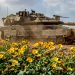 Tank Israel melewati jalan dengan bunga-bunga liar di dekat perbatasan Gaza (The Guardian)