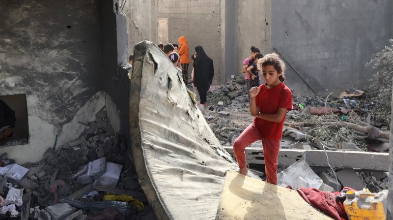 Seorang anak perempuan terdiam menyaksikan rumahnya yang hancur di Gaza (MEE)