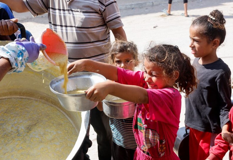 Anak Gaza tampak sangat bahagia saat mendapatkan jatah makanan di dapur umum (Reuters)