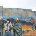 tembok apartheid dan grafiti perjuangan Palestina (Harvard International Review).