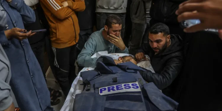 Kerabat berduka di dekat jenazah jurnalis Palestina Mahmoud Wadi yang tewas akibat serangan pesawat tak berawak Israel di Khan Yunis, Gaza, pada 2 Desember 2025. [Abed Rahim Khatib – Anadolu Agency]