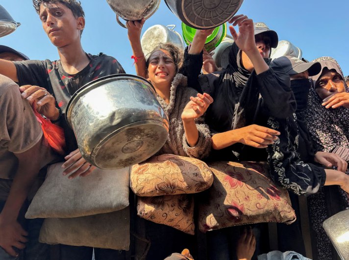 Penduduk Gaza berusaha mendapatkan makanan di dapur umum di Khan Younis (Reuters)