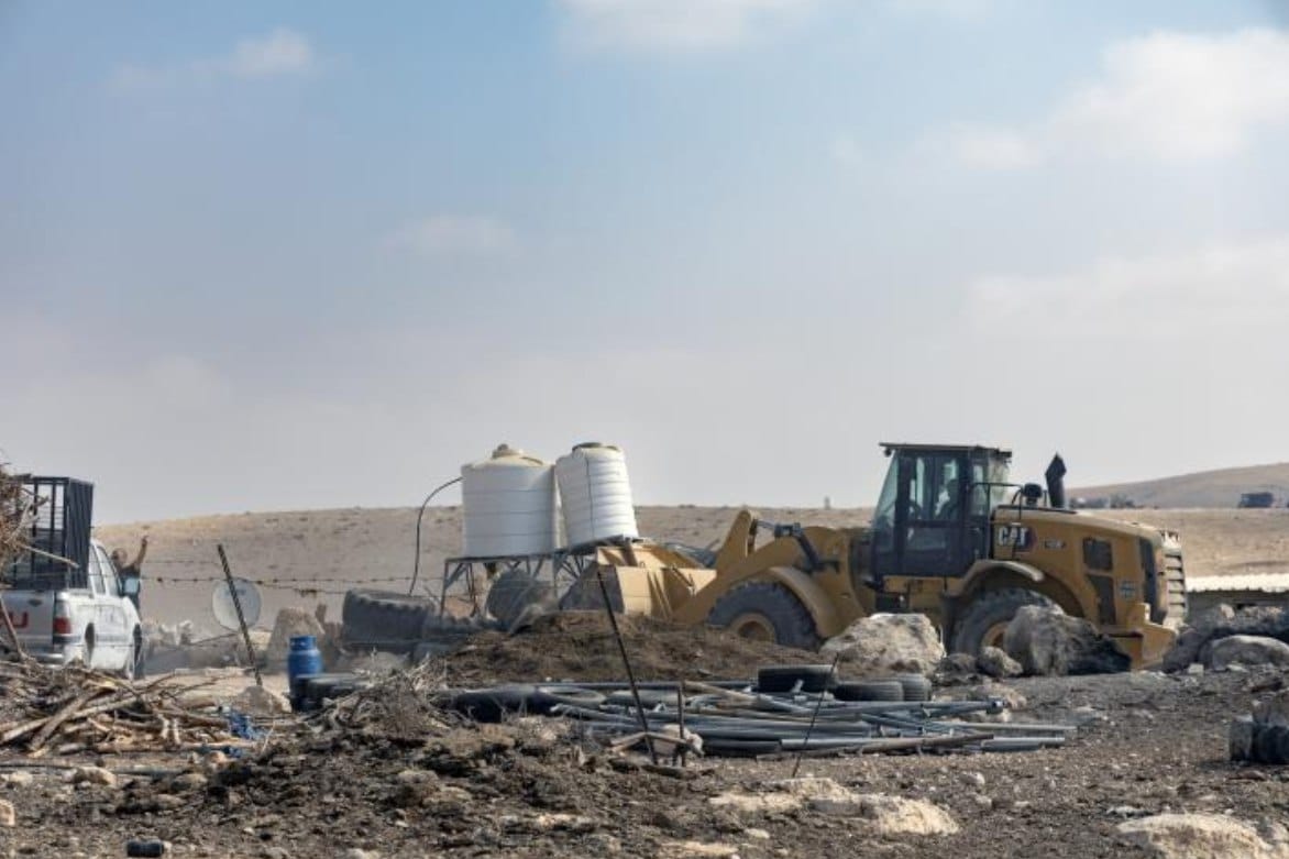 Pasukan kolonial Israel menghancurkan sebuah rumah, dua tangki air, dan infrastruktur tambahan di Khirbet al-Fakhit di Masafer Yatta, Tepi Barat selatan (12/11). Pengusiran ini dilakukan dengan dalih berada di "Zona Tembak 918" (zona "tembak" atau pelatihan militer Israel). Sejak 1967, Israel telah menyatakan sekitar sepertiga wilayah Tepi Barat sebagai "zona militer tertutup". (Basel Adra/ActiveStill)