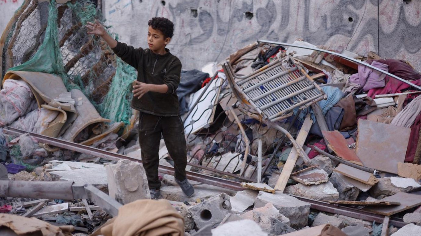 Seorang anak laki-laki Palestina memeriksa lokasi serangan Israel di Jalur Gaza bagian tengah (23/11). Kantor Media Pemerintah Gaza menyatakan bahwa Israel telah melanggar gencatan senjata Gaza yang ditengahi Amerika Serikat setidaknya 497 kali dalam 44 hari, membunuh ratusan warga Palestina sejak gencatan senjata mulai berlaku pada 10 Oktober lalu. (Reuters/ OHCHR/ Al Jazeera)