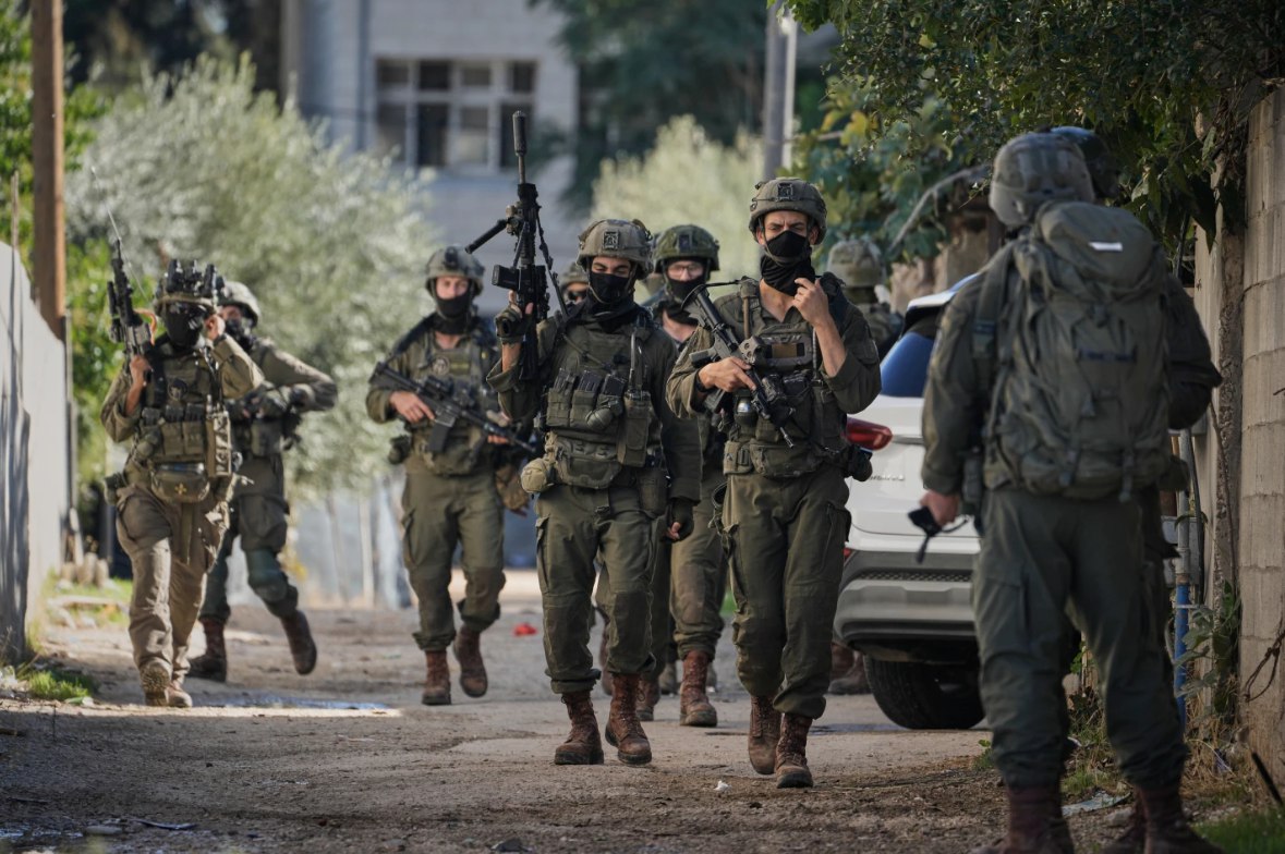 Tentara Israel berpatroli di jalan-jalan Tubas di Tepi Barat dalam sebuah operasi militer (26/11). Ratusan tentara Israel yang didukung oleh kendaraan lapis baja telah melakukan penggerebekan di kota tersebut dan memberlakukan jam malam. Jalan-jalan ditutup dengan penghalang tanah, sementara keluarga-keluarga Palestina dipaksa meninggalkan rumah mereka agar pasukan Israel dapat menggunakan bangunan-bangunan tersebut. (Majdi Mohammed/AP/ The Guardian/ ABC)