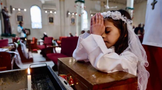 Seorang anak perempuan berdoa di Gereja Keluarga Kudus selama perayaan Natal (MEE)