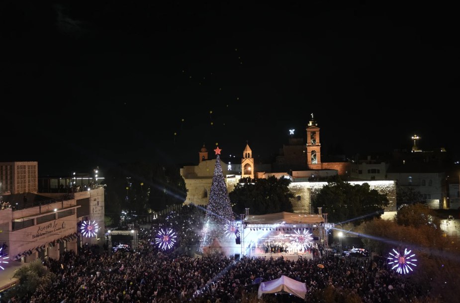 Warga Palestina berpartisipasi dalam acara penyalaan pohon Natal di Lapangan Manger, di sebelah Gereja Kelahiran Yesus, menjelang Natal di Betlehem, Tepi Barat (6/12) Selama dua Natal, bersamaan dengan agresi Israel di Gaza, perayaan ikonik itu dihentikan. Namun pada tahun ini, Natal perlahan kembali dirayakan di Betlehem. (Mahmoud Illean/AP Photo)