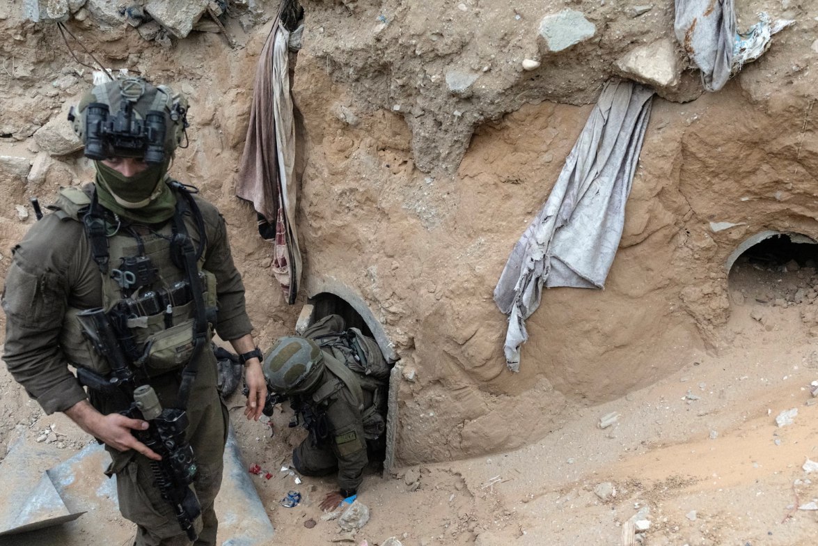 Tentara Israel di pintu masuk terowongan Hamas yang diduga sebagai tempat menahan jenazah perwira Israel Hadar Goldin, di Rafah (9/12). Rekaman yang baru-baru ini dibagikan oleh IOF menunjukkan labirin terowongan yang remang-remang, tempat para sandera ditahan, membentang sekitar 80 kaki di bawah permukaan. (Nir Elias/Reuters/ The Independent)