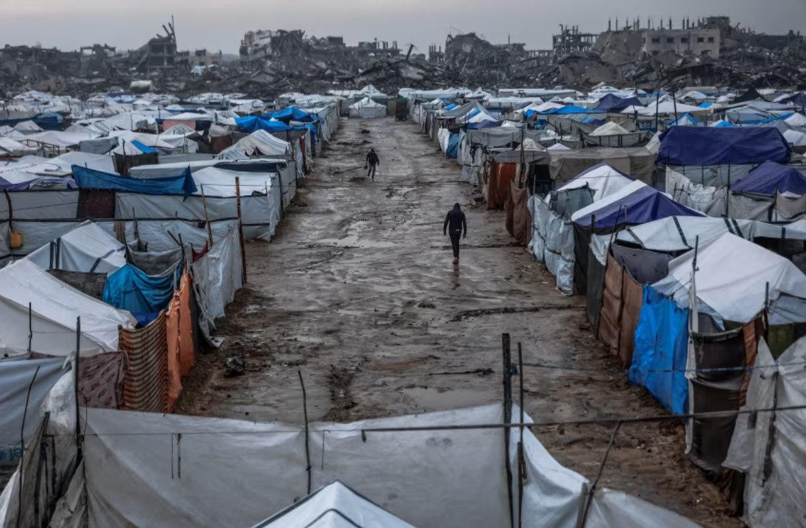 Lorong berlumpur terlihat sebuah kamp darurat yang menampung pengungsi Palestina di lingkungan Zeitoun, Kota Gaza (11/12). Kondisi cuaca buruk selama 72 jam terakhir di Gaza telah menyebabkan 14 orang terbunuh, termasuk tiga anak. (Omar Al-Qattaa/AFP/CNN)