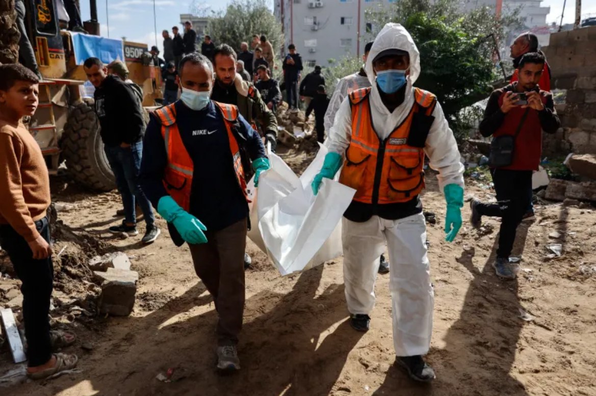 Anggota Pertahanan Sipil Palestina membawa kantong jenazah berisi sisa-sisa jenazah seorang anggota keluarga Salem yang ditemukan dari reruntuhan rumah mereka, yang hancur pada tahun 2023 di lingkungan Remal, Kota Gaza, 15 Desember 2025. (AFP)