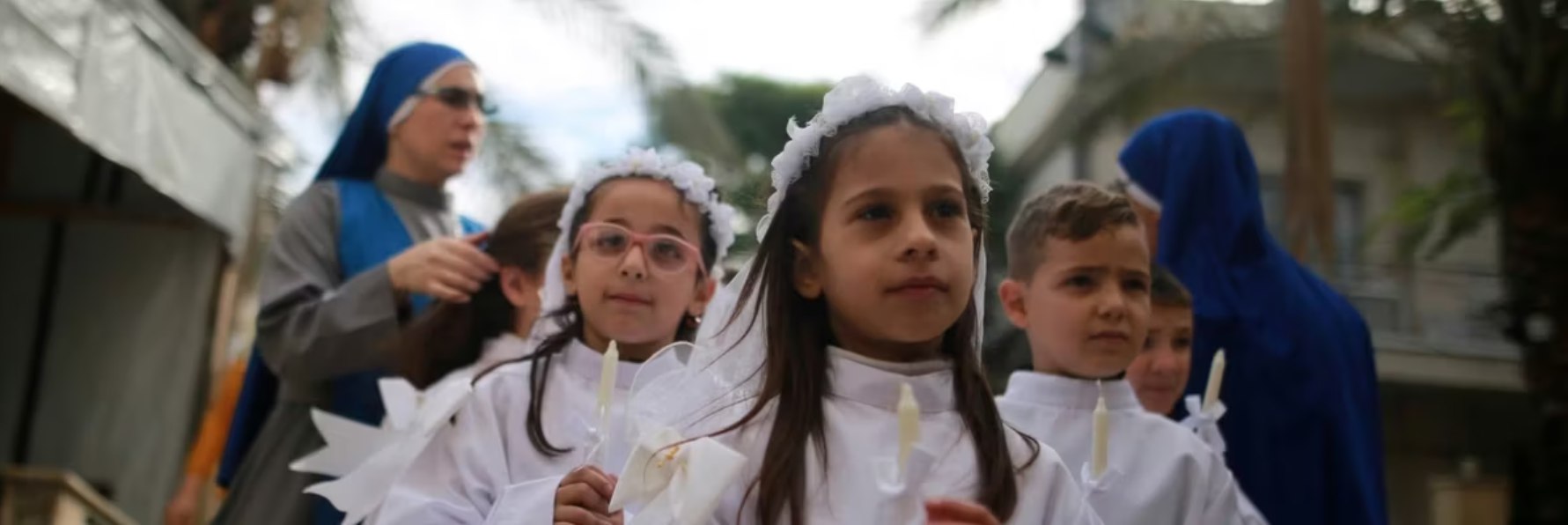 Anak-anak mengikuti Misa Natal di Paroki Keluarga Kudus di Kota Gaza (21/12). Sementara Betlehem merayakan Natal penuh untuk pertama kalinya sejak genosida, gereja-gereja di Gaza masih harus merayakan Natal di dalam ruangan karena IOF terus melanjutkan serangannya meskipun ada "gencatan senjata". (Majdi Fathi Nur/ Commondreams/ MEE)