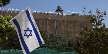 Para pemukim memasang bendera Israel di pagar batu Masjid Ibrahimi di Hebron (MEMO)