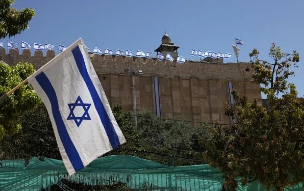 Para pemukim memasang bendera Israel di pagar batu Masjid Ibrahimi di Hebron (MEMO)