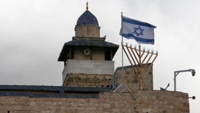 Pemukim Yahudi memasang bendera Israel dan menorah Hanukkah di Masjid Ibrahimi (MEE)