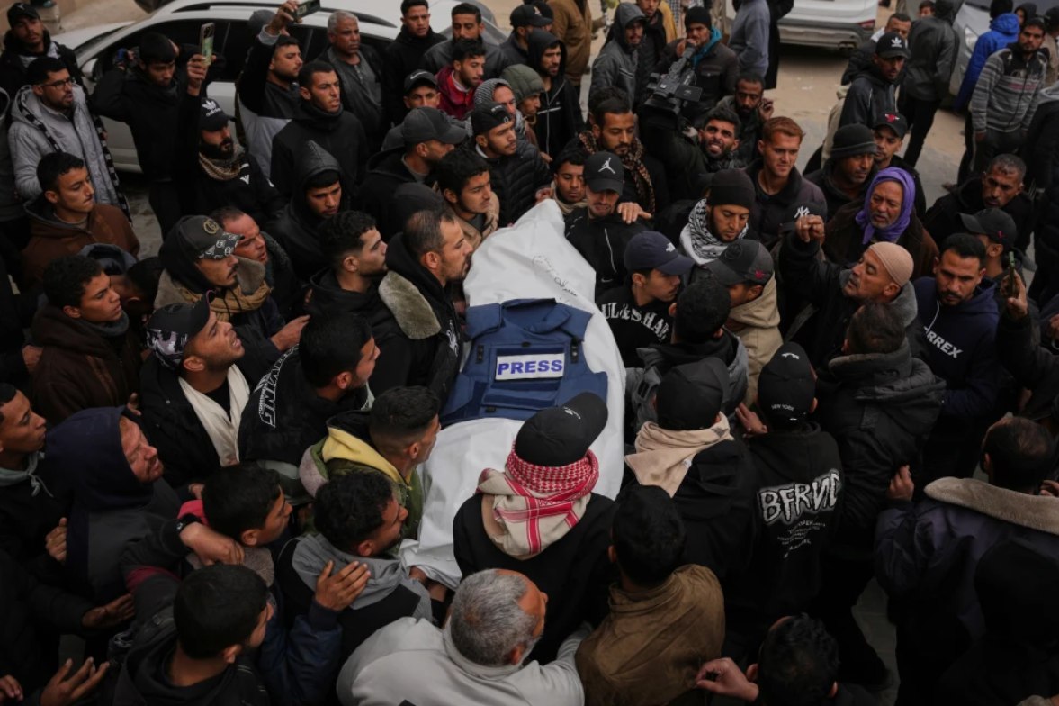Para pelayat mengusung jenazah Anas Ghoneim, salah satu dari tiga jurnalis Palestina yang terbunuh dalam serangan Israel terhadap kendaraan komite Mesir, selama pemakamannya di Khan Younis, Jalur Gaza selatan (22/1). Dua jurnalis lainnya adalah Abdel Shaat dan Mohamed Salah Qashta. Pembunuhan ini menunjukkan pelanggaran gencatan senjata dan upaya Israel untuk membungkam suara kebenaran yang datang dari Gaza. (Abdel Kareem Hana/ AP)